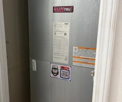 RUNTRU vertical HVAC air handler in closet with insulated refrigerant lines, PVC condensate drain and QR service sticker