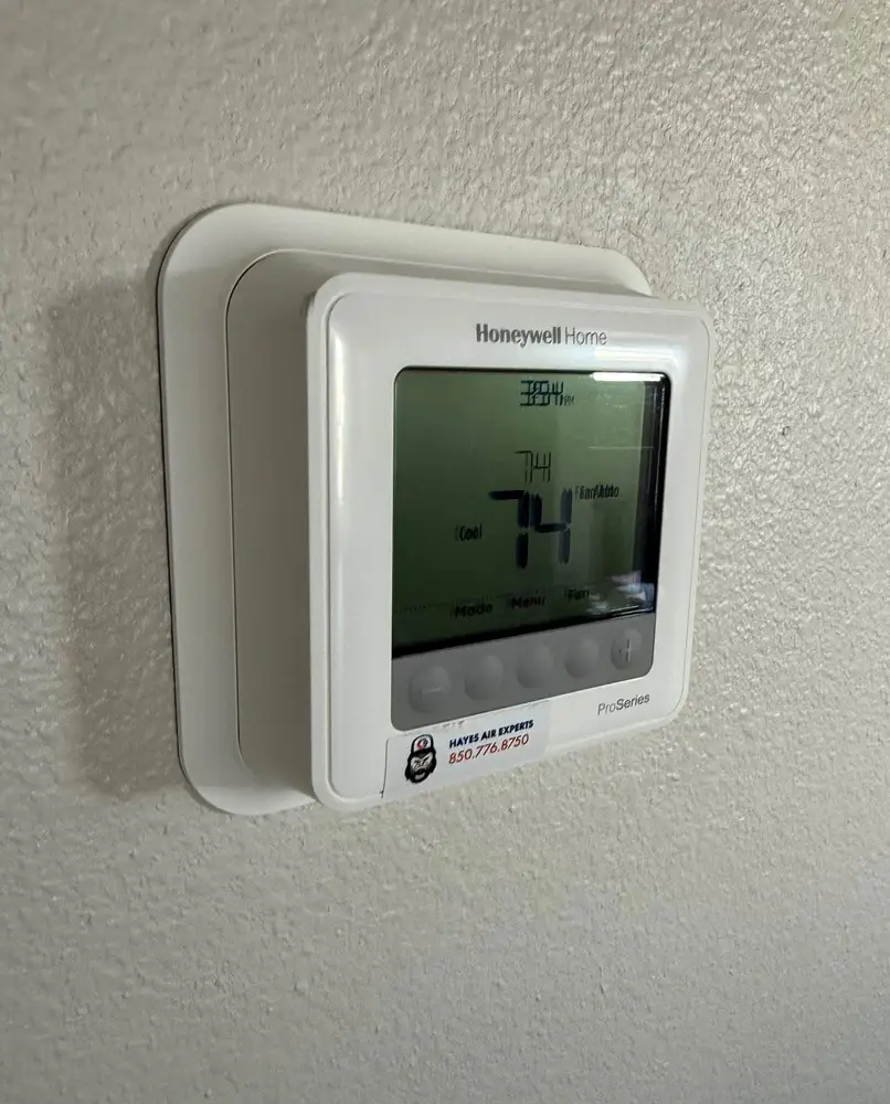 Honeywell Home digital thermostat ProSeries mounted on textured wall displaying 74°F in cooling mode.